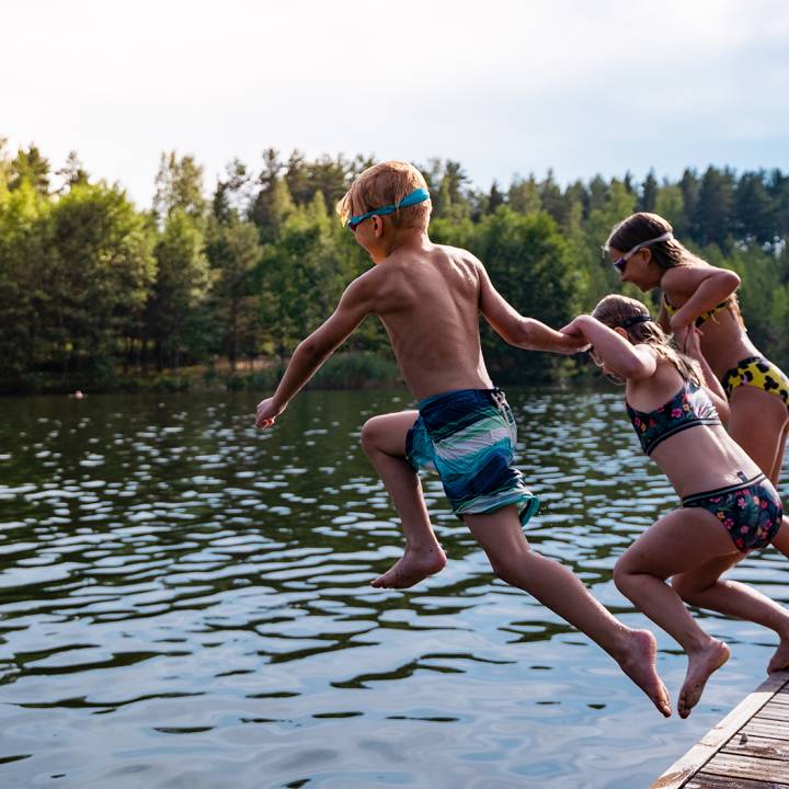 Valokuva: Lapset hypp&auml;&auml;v&auml;t laiturilta uimaan